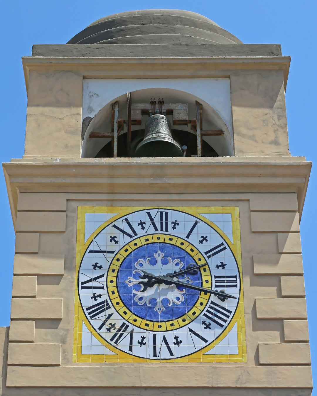 Vue proche de la Tour de l'horloge de l'île de Capri, avec un ciel bleu en arrière plan.