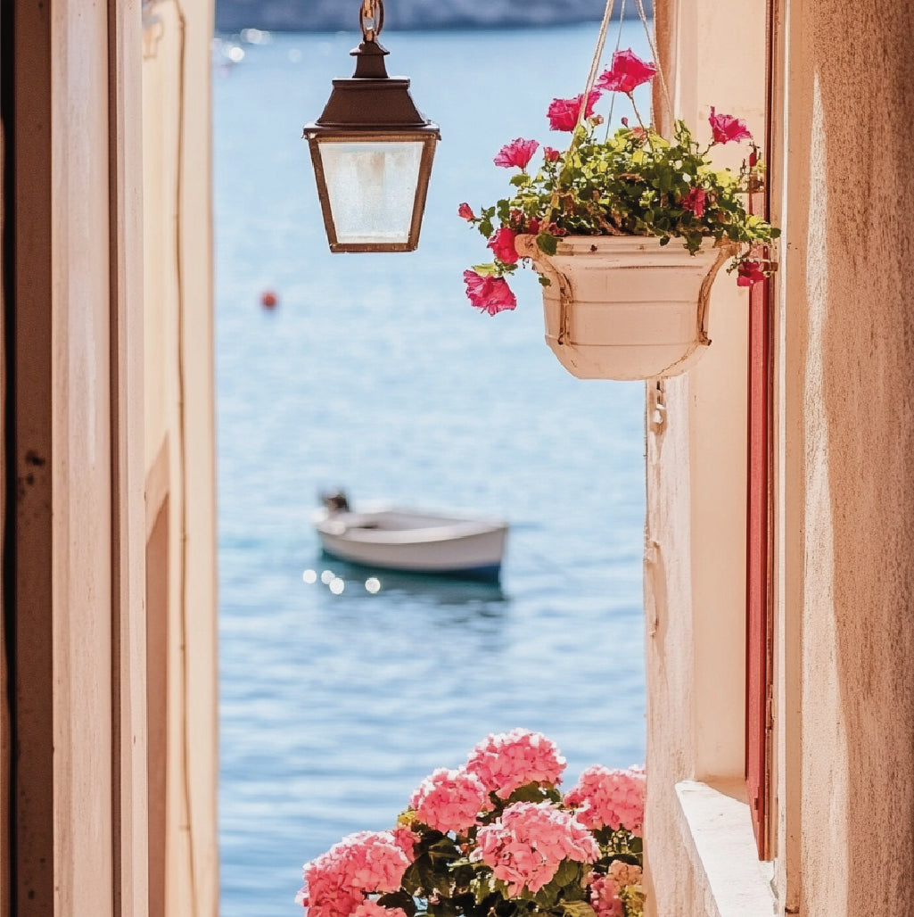 Photographie montrant la mer, avec des fleurs roses au premier plan.