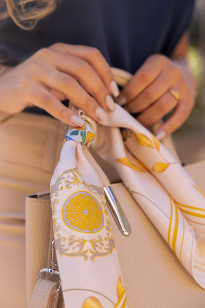 Carré de soie Capri Eleganza blanc et or à motifs de citrons, 45 x 45 cm, noué à l'anse d'un sac, twill roulotté main en édition limitée