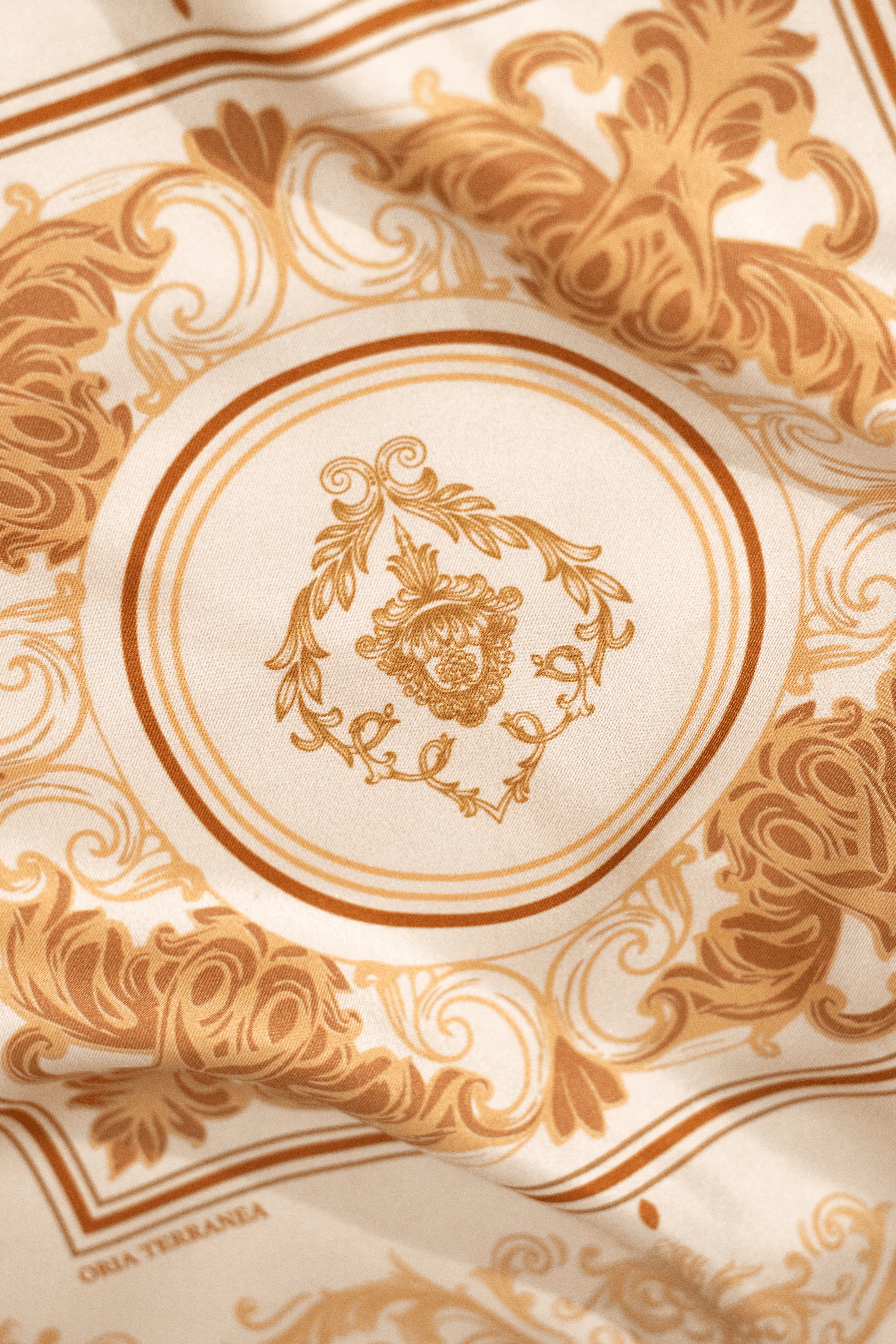 Vue proche du foulard Sole di Sicilia, avec des tons ors, crèmes, ivoires et marrons.