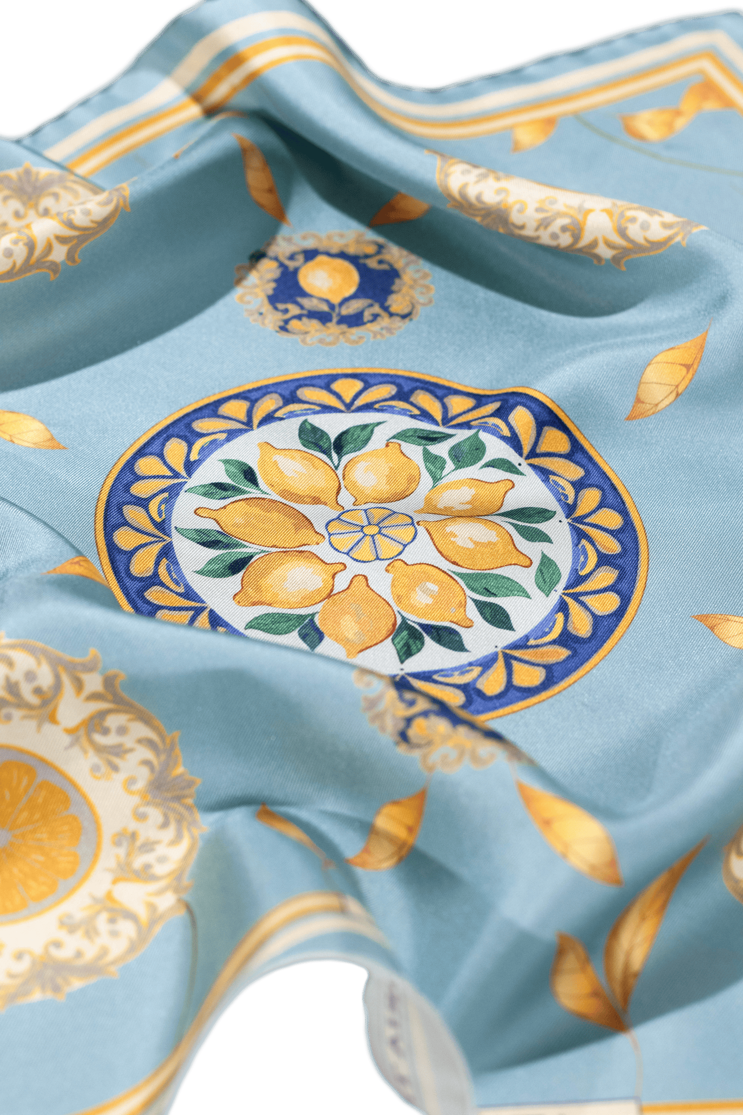 Vue détaillée du foulard Capri Eleganza Bleu, avec des motifs de citrons, des feuilles dorées et des références à la céramique de l'île. 